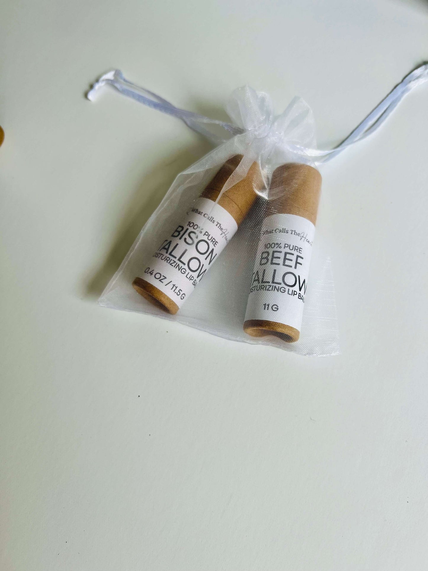 Two organic lip balm tubes in a gift bag, featuring beef tallow and bison tallow formulations.