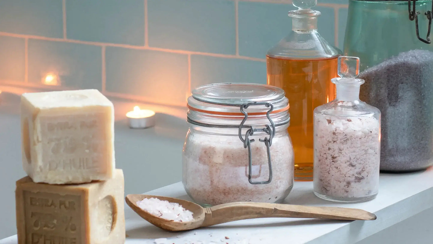 Serene bath setup with natural bath salts, soap bars, and essential oils, creating a relaxing atmosphere.