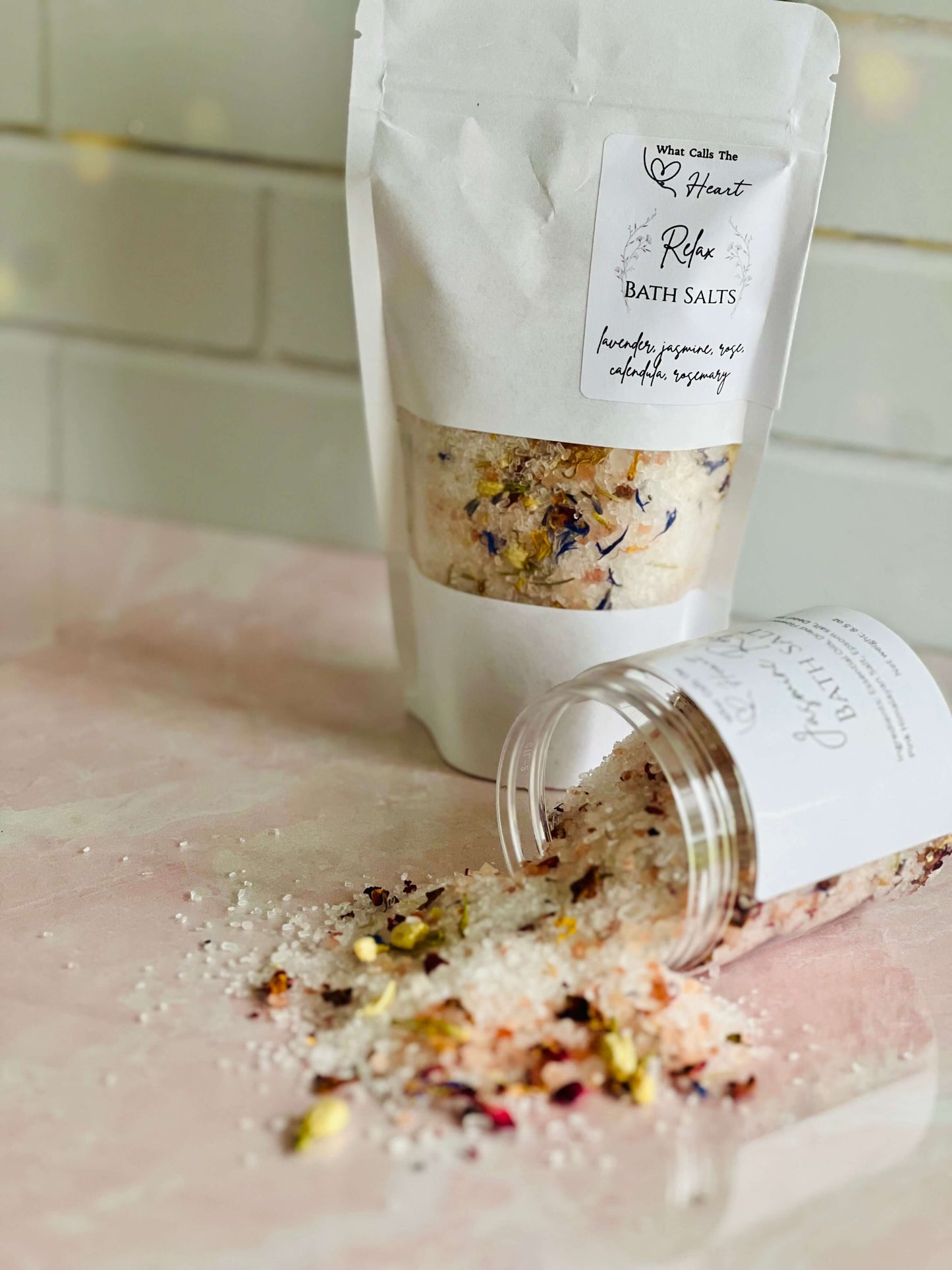 Jasmine Rose Bath Salts in a container with flowers spilling over, promoting relaxation and skin renewal.