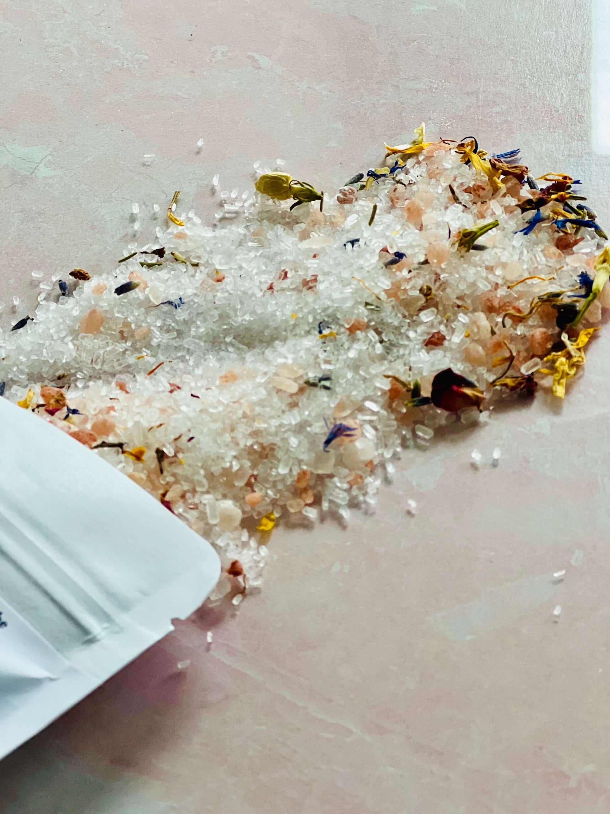 Handmade bath salt soak with Himalayan pink salt and dried flowers for a relaxing soak experience.