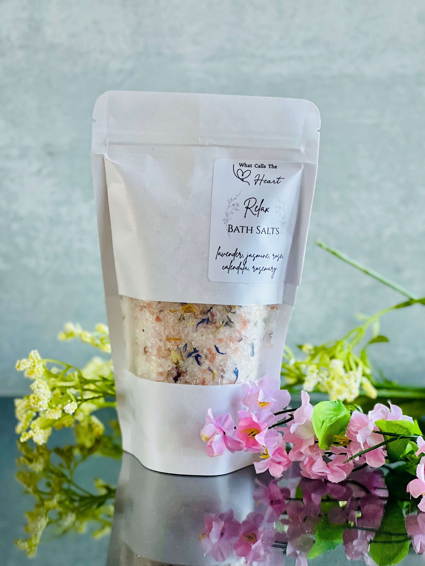 Pack of handmade bath salts featuring natural ingredients and floral accents, promoting relaxation and skin renewal.