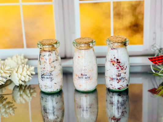Handcrafted bath salts in glass jars with cork stoppers; lavender, rose, and unscented varieties.