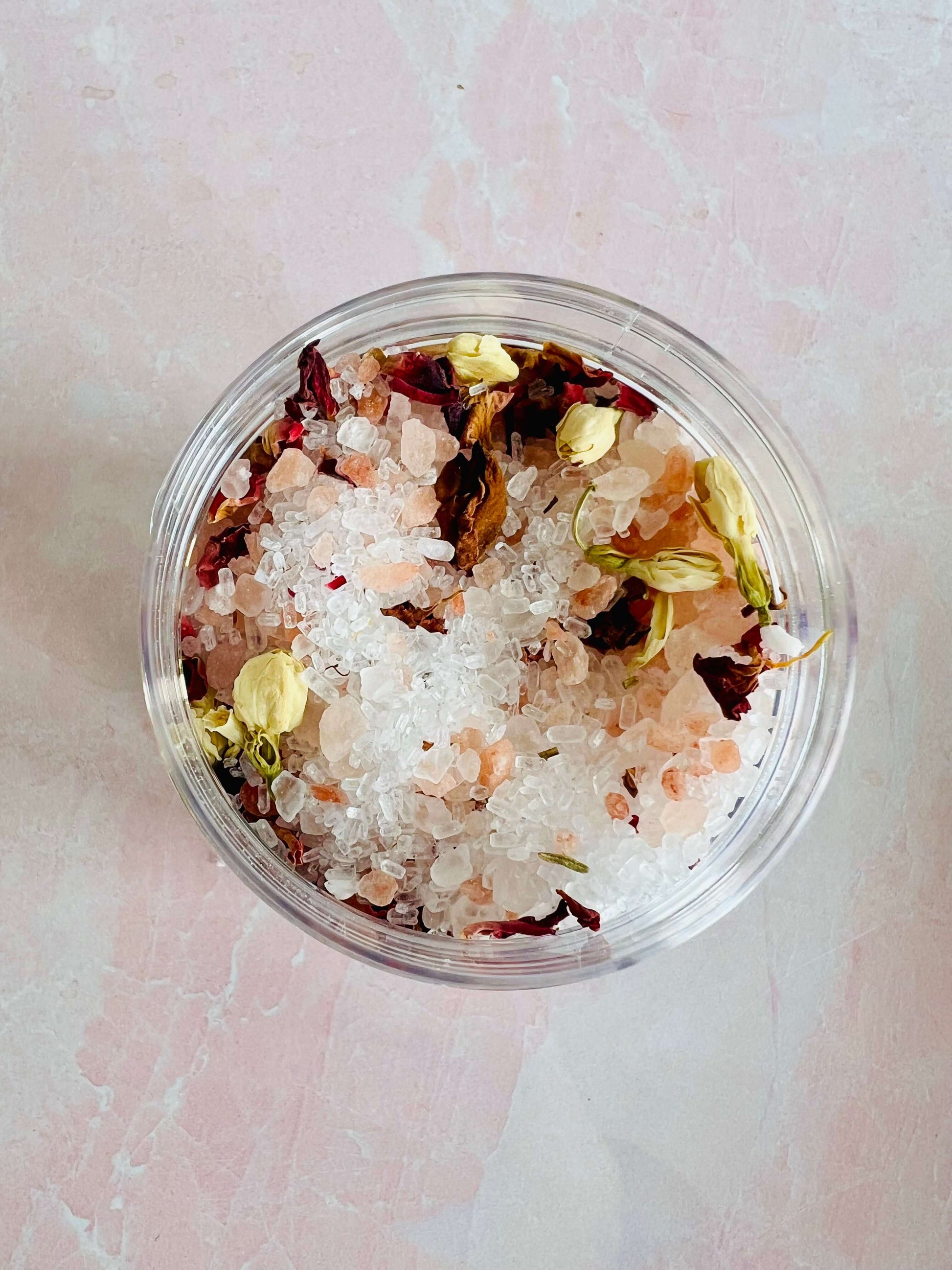Jasmine Rose Bath Salts in clear container with pink Himalayan salt and dried flower petals.