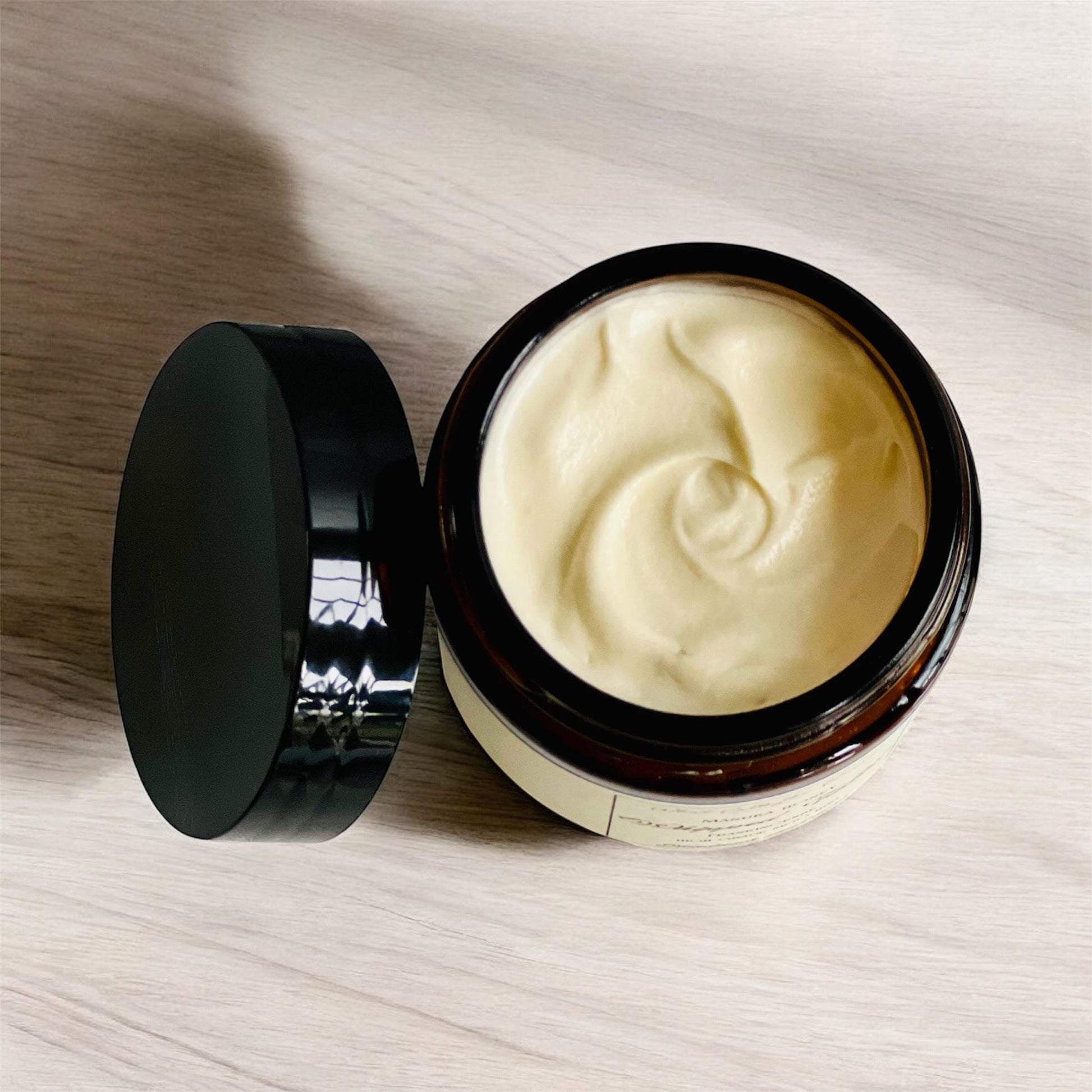 The jar has the lid off showing the smooth texture of the whipped tallow.